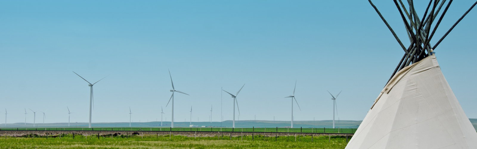 Image of tipi in front of windmill farm