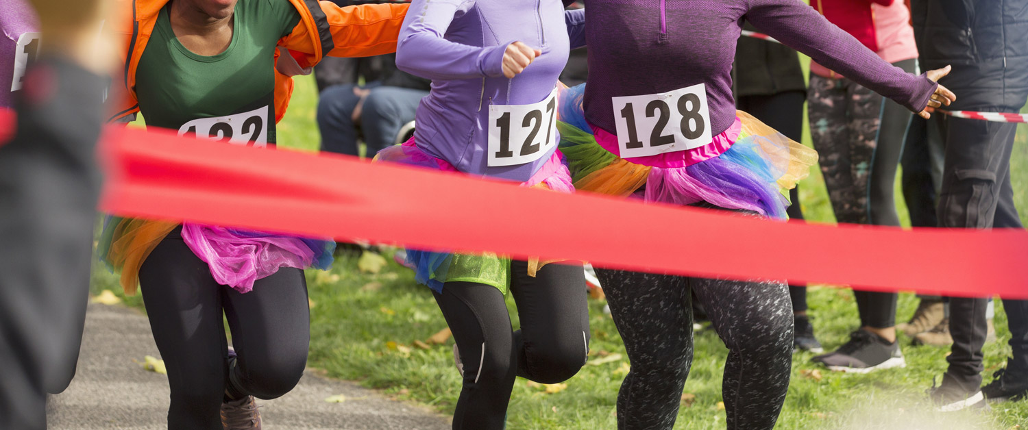 trois femmes qui font une course et approchent de la ligne d'arrivée